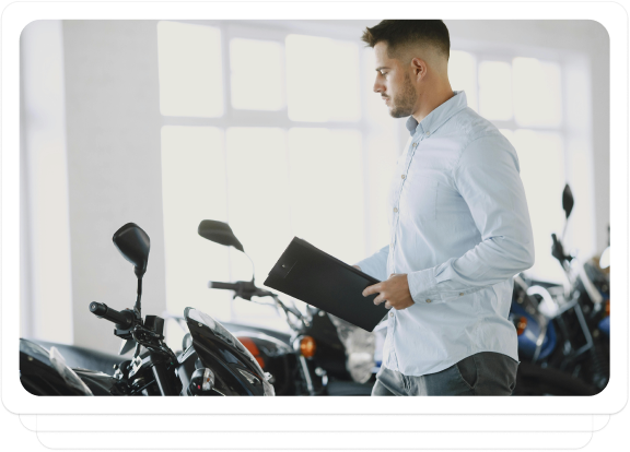 Auto dealer inspecting motorcycles in a showroom, preparing them for auction