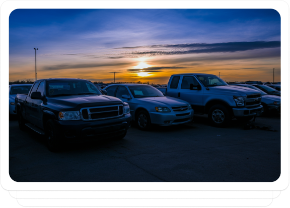 Parked salvaged vehicles at sunset, ready for auction