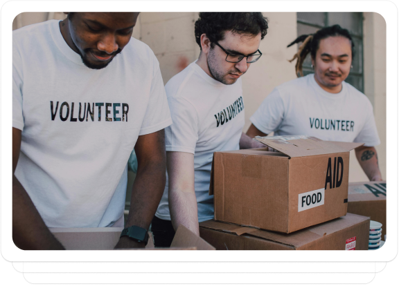 Team of volunteers packing aid boxes labeled "Food Aid" during a fundraising event outdoors.